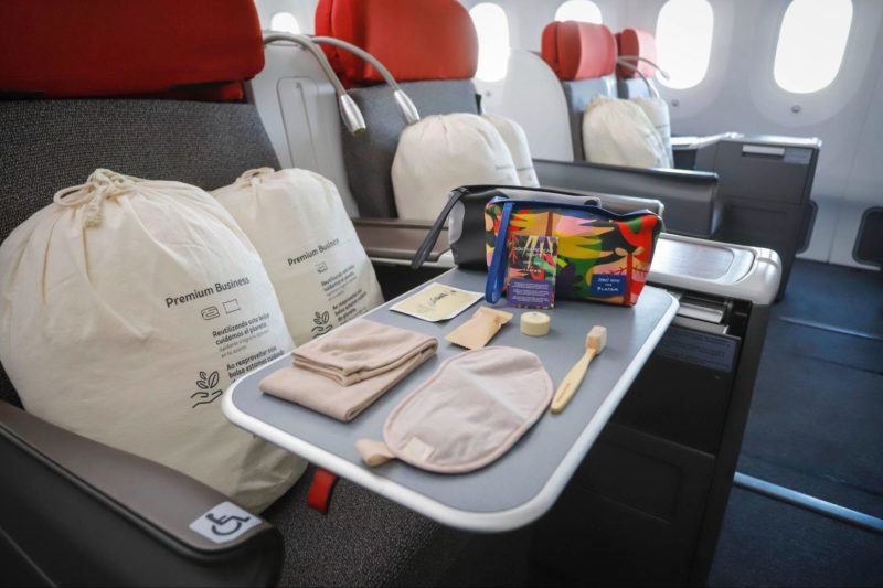 a tray with food and a bag on the side of the seat of an airplane