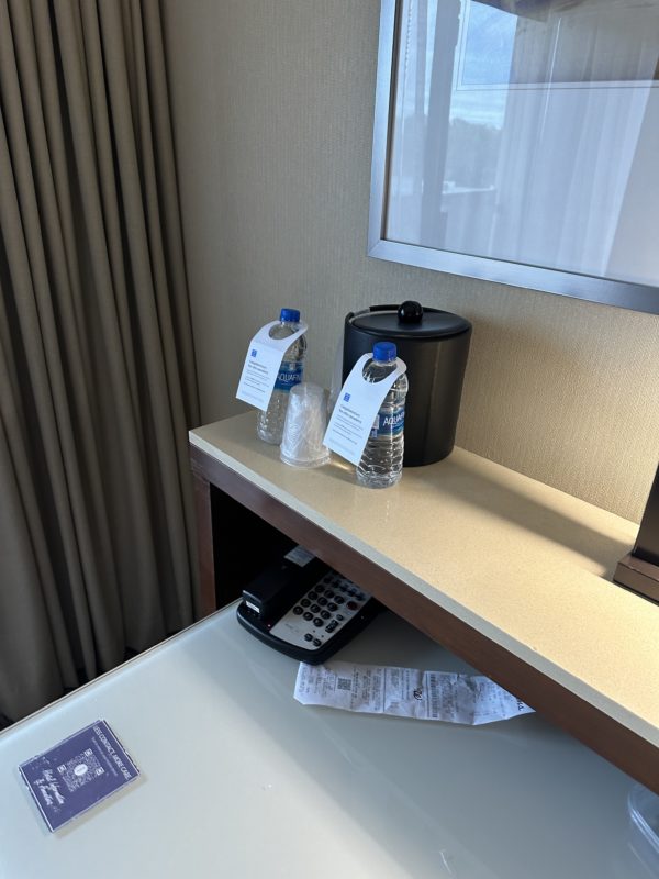 a hotel room with a phone and water bottles