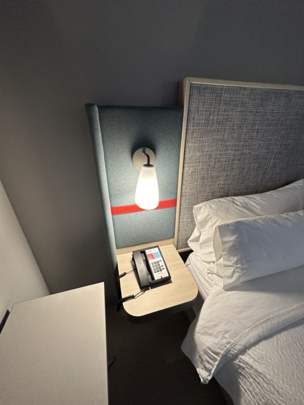 a phone on a table next to a bed