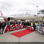 a group of people standing in front of a plane