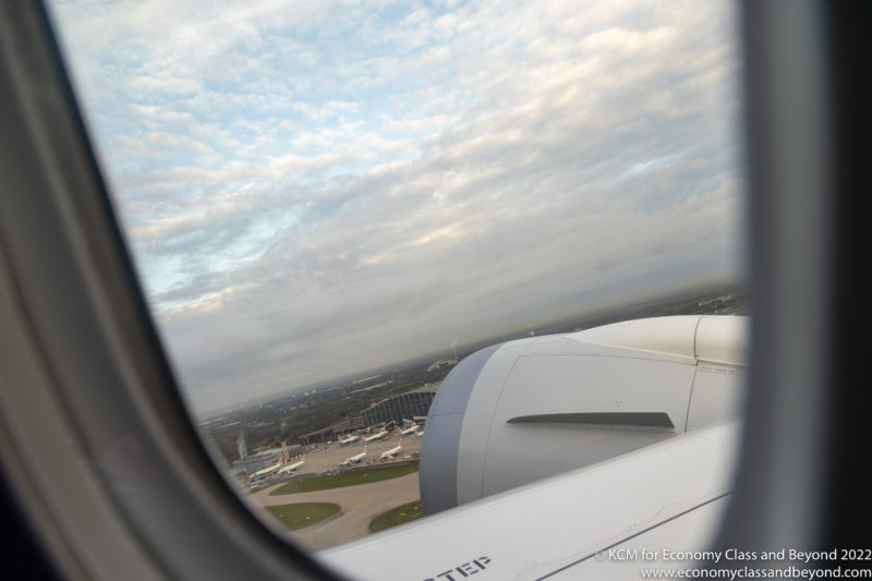 an airplane wing with a view of the city from the window