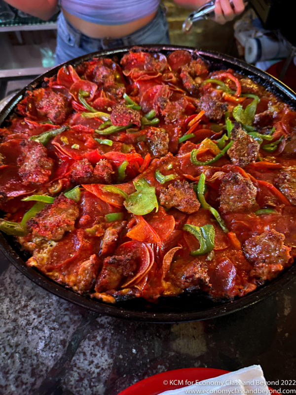a pan of pizza with pepperoni and meat