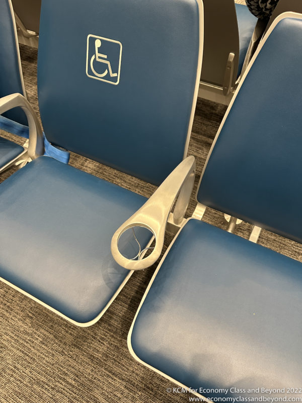 a group of blue chairs with a white arm rest
