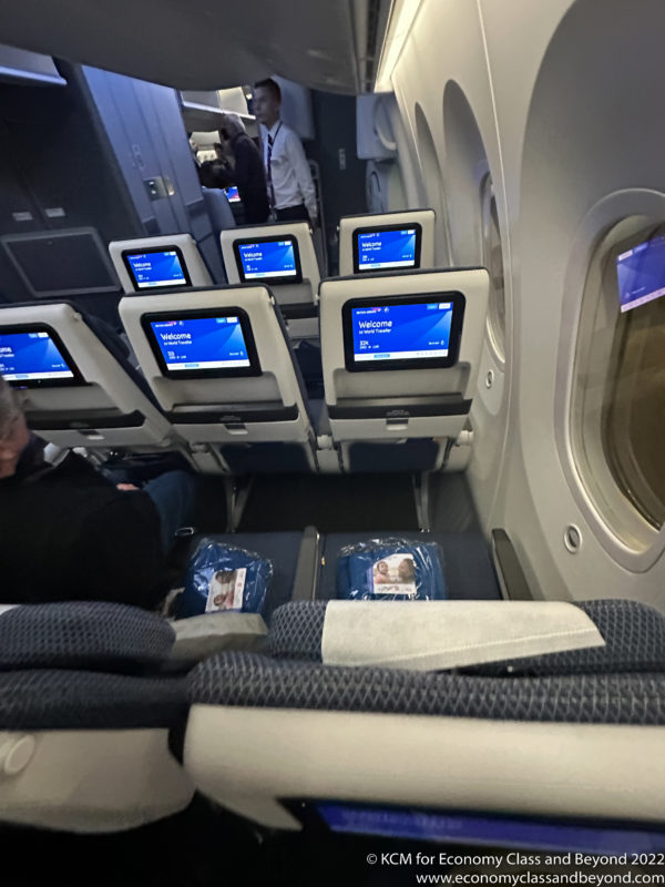 a group of people sitting in a plane with monitors