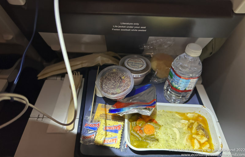 food on a tray with a bottle of water and a sandwich