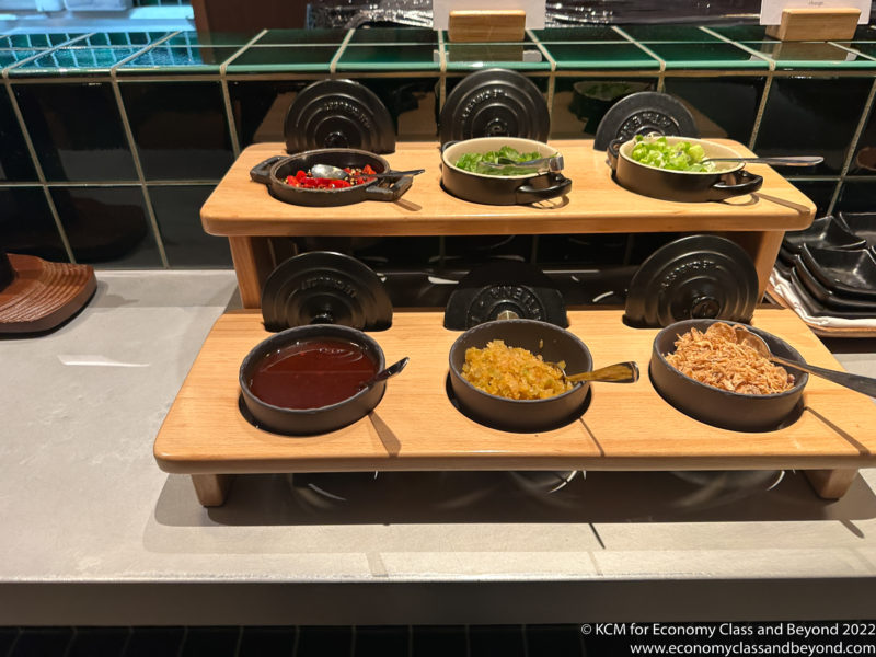 a wooden tray with bowls of food on it