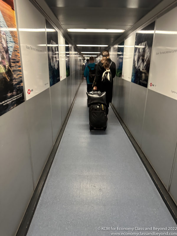 a couple of people walking down a hallway with luggage