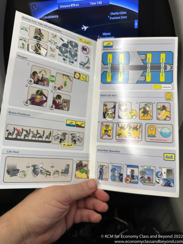 a hand holding a booklet with instructions