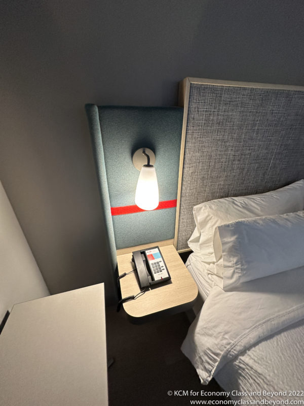 a phone on a table next to a bed