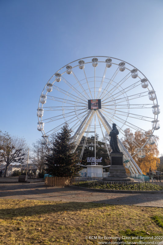 a ferris wheel with a statue in front of it