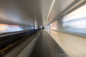 a blurry image of a person standing on a moving walkway