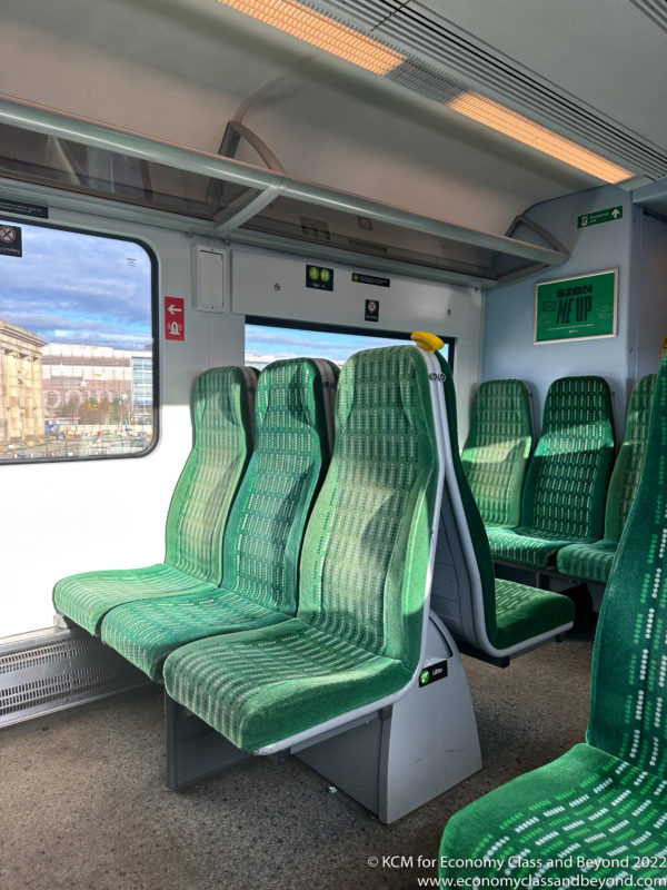 a row of green seats in a train