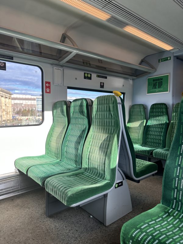 a row of green seats in a train