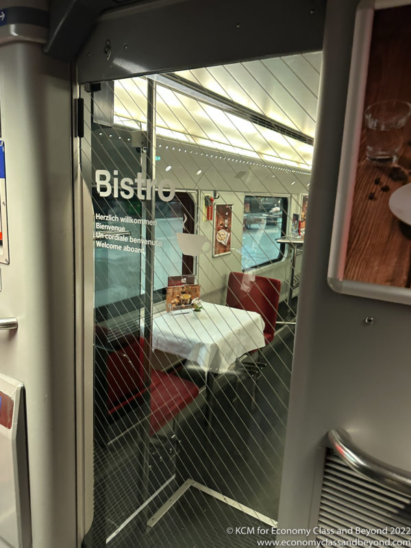 a glass door with a table and chairs in a train