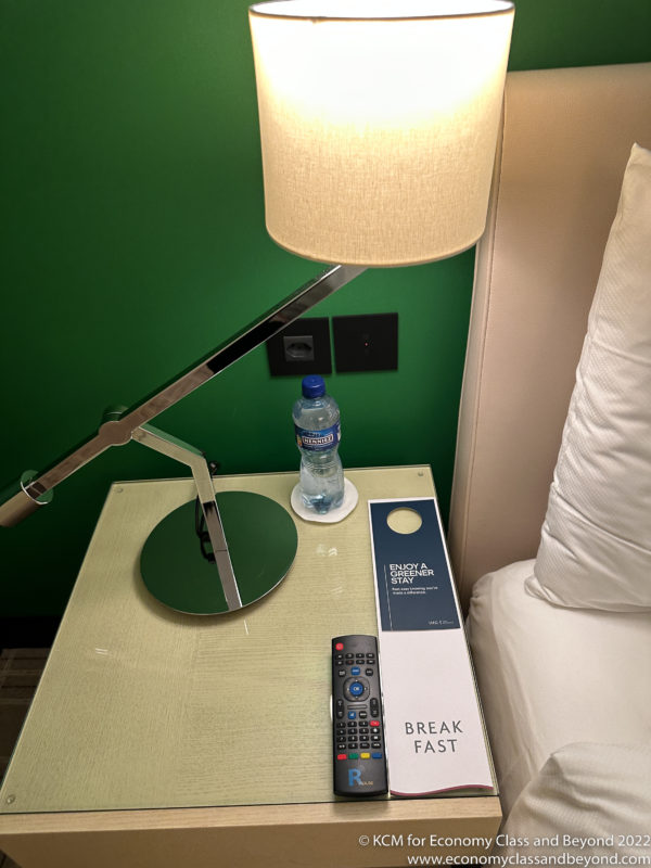 a lamp on a table next to a bottle of water