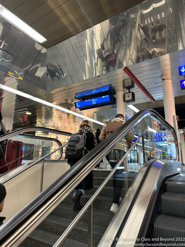 people walking up an escalator