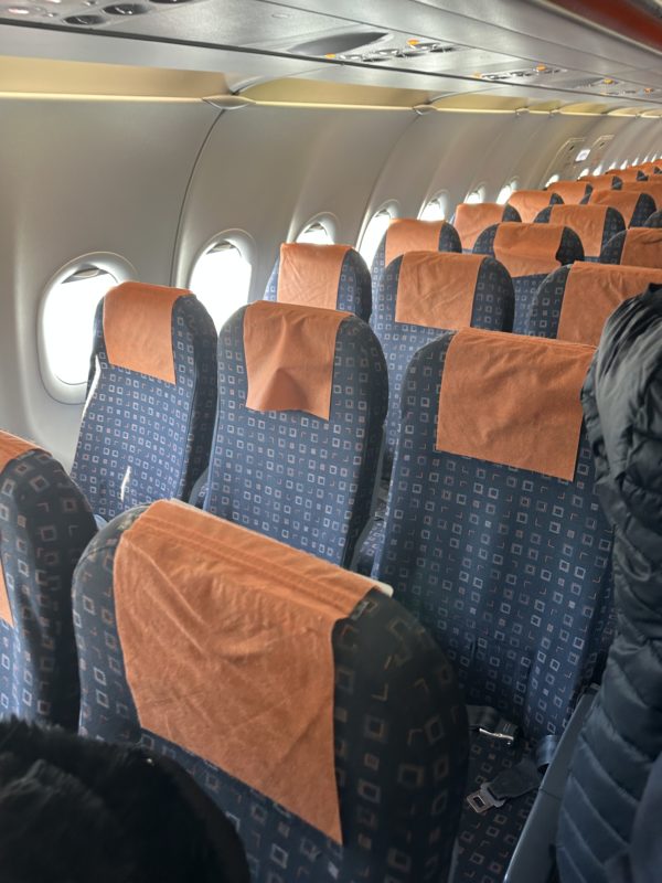 seats in an airplane with orange cloth