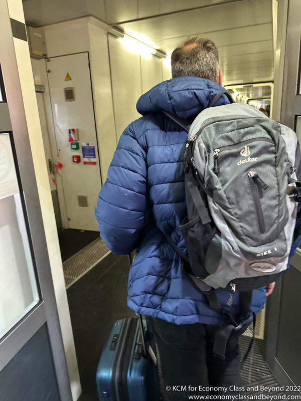 a man wearing a backpack and standing in a train