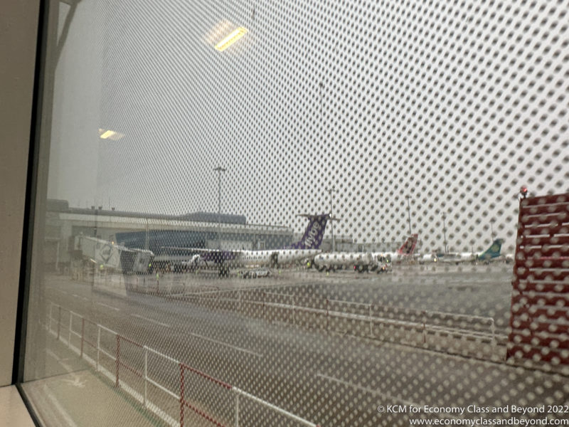 a view of airplanes on a runway from a window