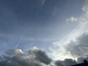 a blue sky with clouds and a jet trail