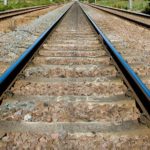 a train tracks with rocks and grass