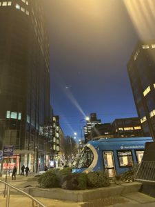 a blue train on a city street