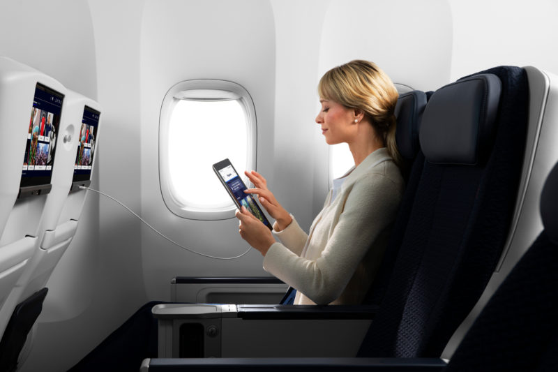 a woman sitting in an airplane using a tablet