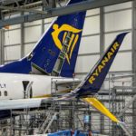 a blue and yellow tail of an airplane in a hangar