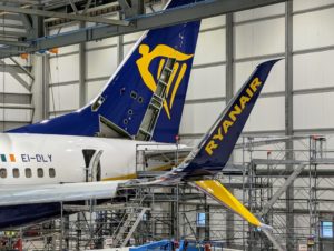 a blue and yellow tail of an airplane in a hangar