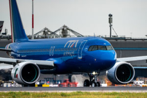 a blue airplane on a runway