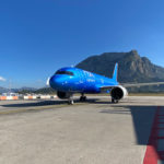 a blue airplane on a runway