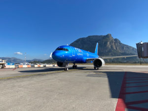 a blue airplane on a runway
