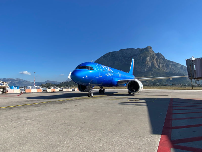 a blue airplane on a runway