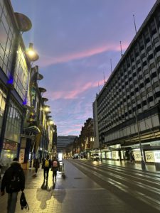 a street with buildings and people walking on it