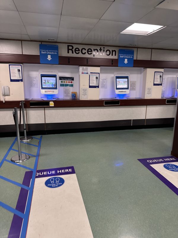 a check in counter with a sign and a few electronic devices