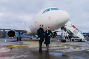 a man and woman standing in front of an airplane