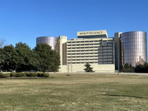 a large building with a lawn and trees