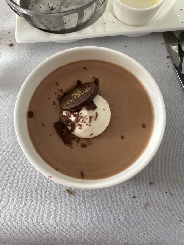 a bowl of chocolate pudding with a cookie on top