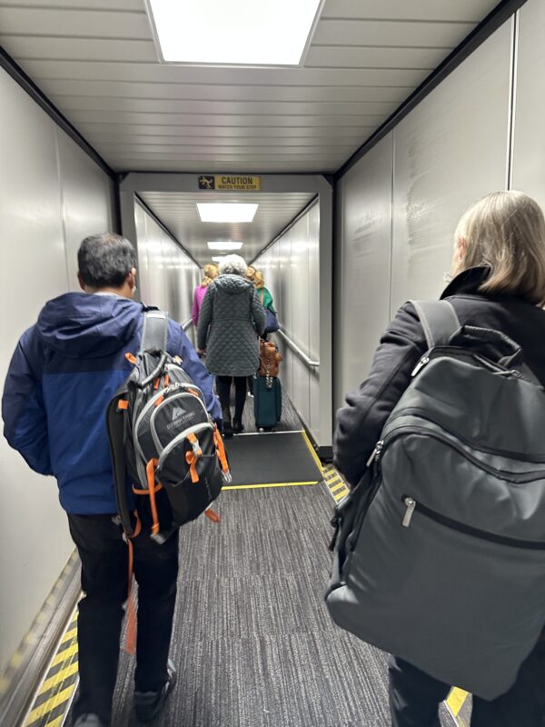 people in a hallway with luggage