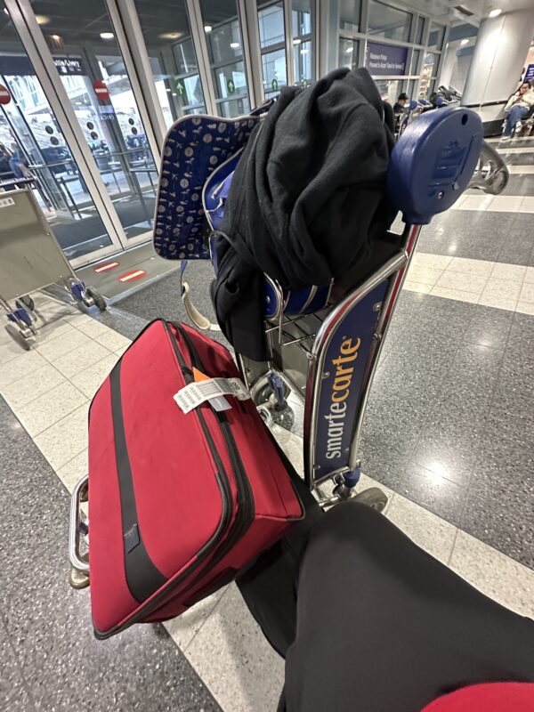 a luggage cart with a stack of luggage