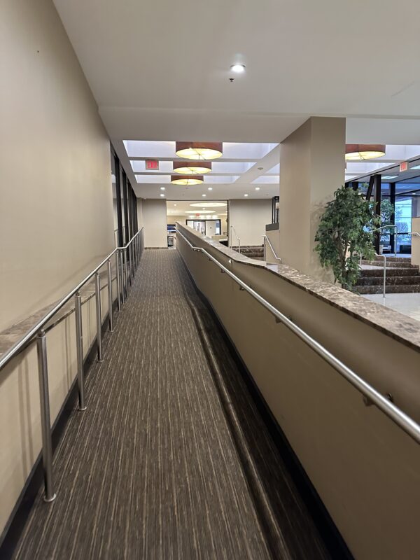a walkway with handrails and a walkway in a building