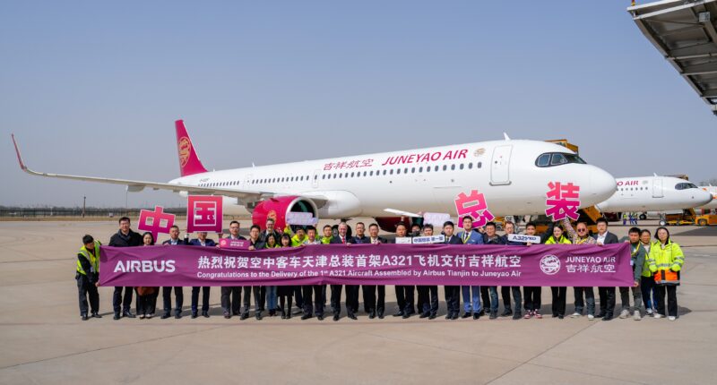 a group of people holding a banner in front of a plane