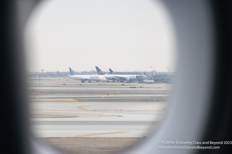 a view through a window of airplanes on a runway
