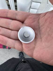 a hand holding a small white object