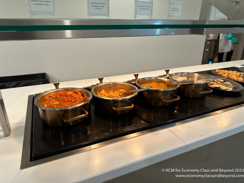 a row of pots of food on a counter