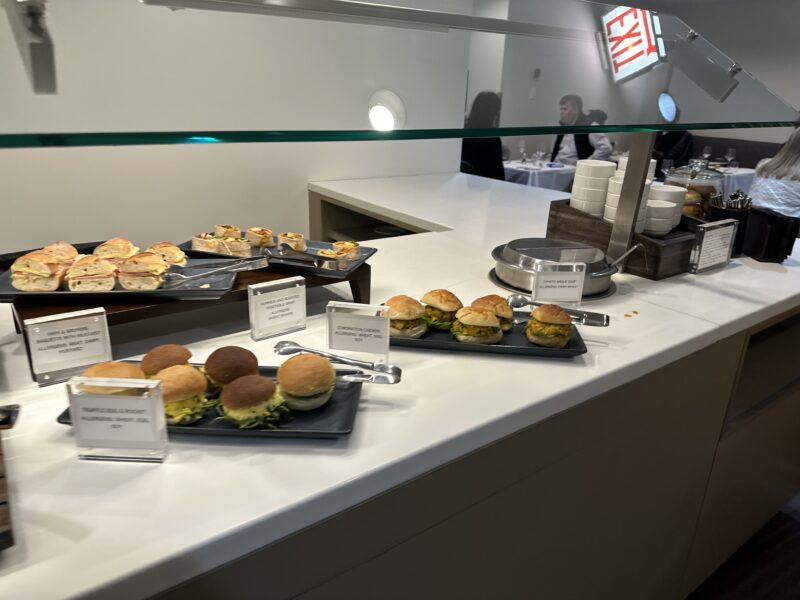 a counter with plates of sandwiches and plates of food