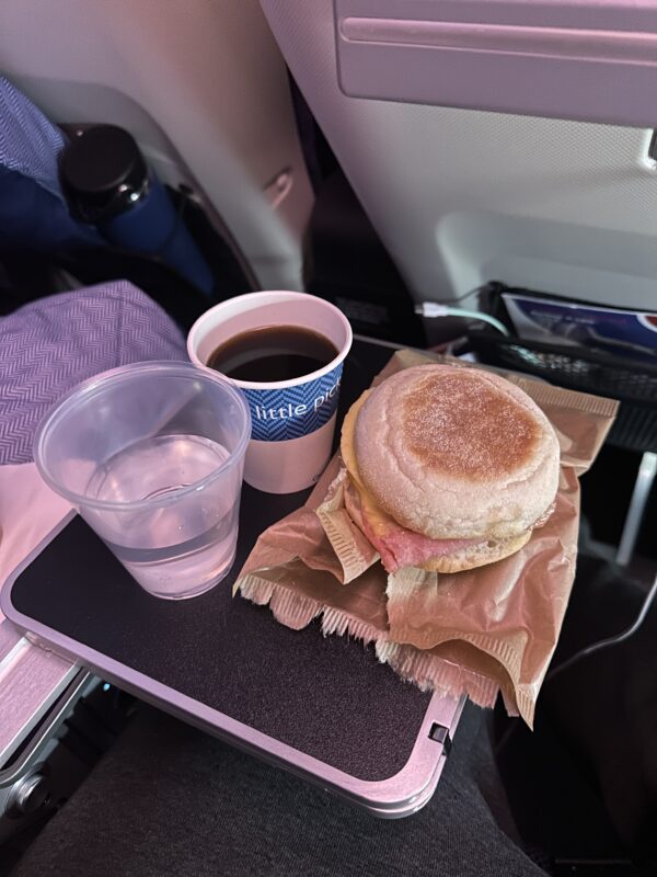 a sandwich and a cup of coffee on a tray