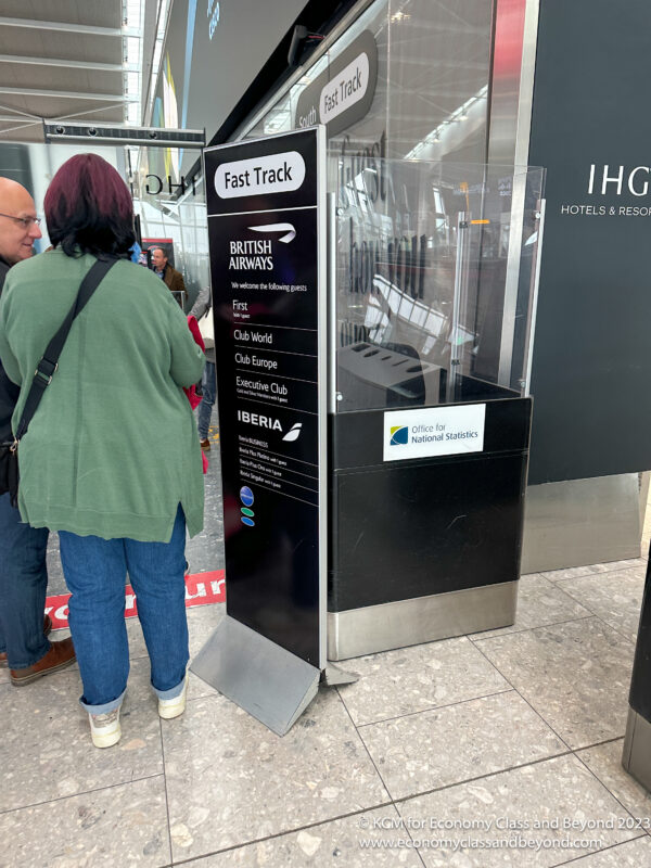 a couple of people standing next to a fast track ticket booth