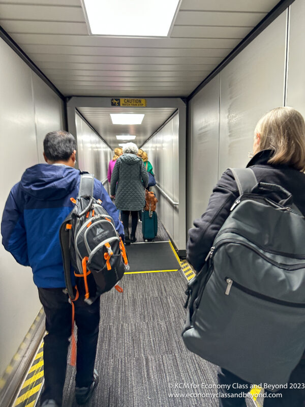 people walking down a hallway with luggage