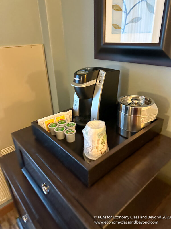 a coffee maker and coffee cups on a tray